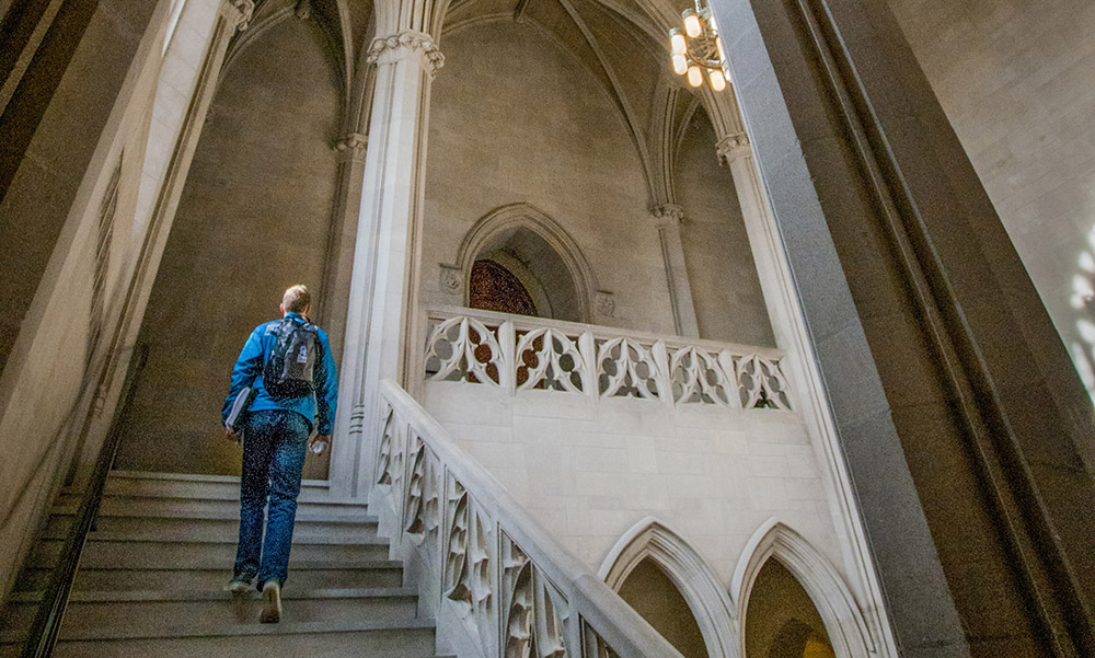 student ascending gothic stairway